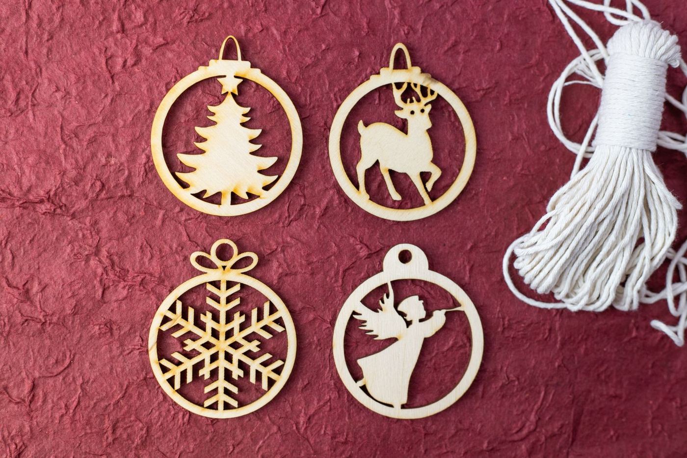 Laser-cut wooden ornaments laid out on red fabric