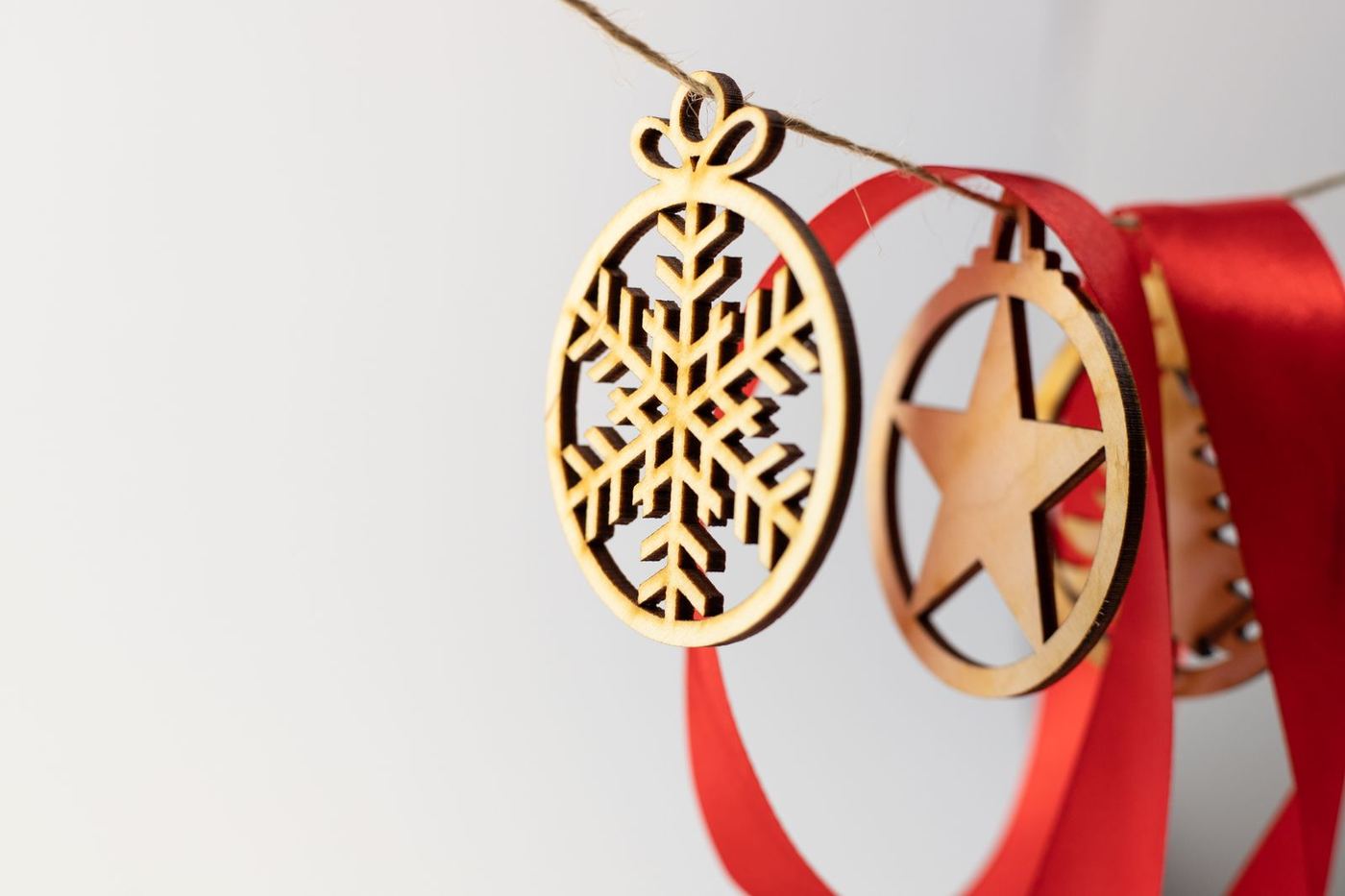 Wooden snowflake and star ornaments on red ribbons